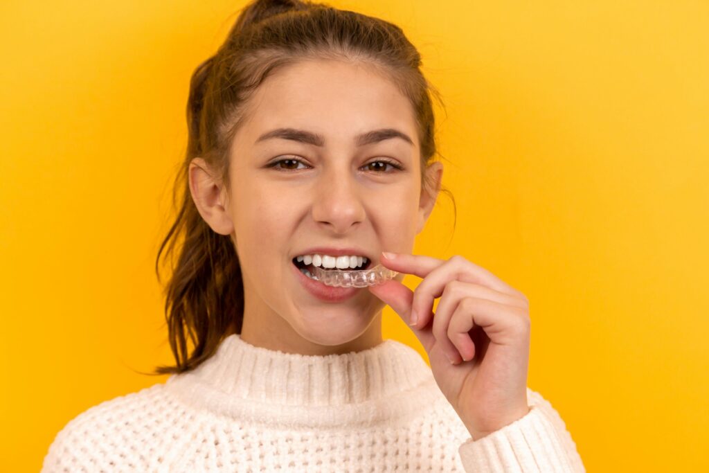 girl holding her clear aligner in narre warren