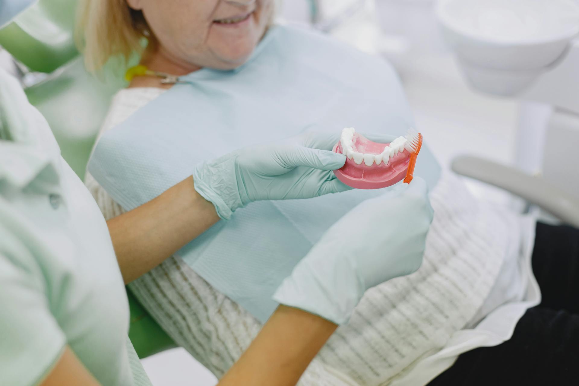 A dentist showing a patient her custom dentures at Victor Crescent Dental Clinic in Narre Warren, offering comfortable and natural-looking tooth replacement solutions.
