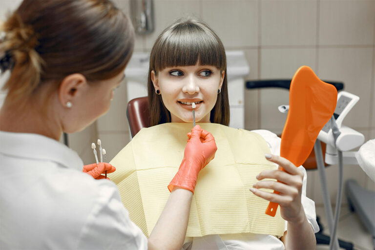 A dentist holding custom dental crowns for a patient at Victor Crescent Dental Clinic in Narre Warren, offering high-quality restorations for a natural, long-lasting smile.